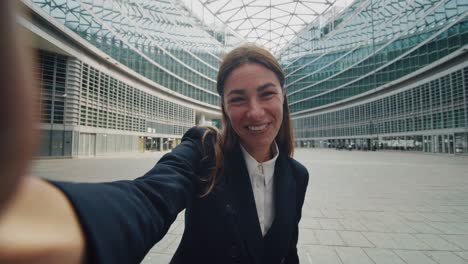 fotografía cinematográfica de una mujer de negocios haciendo una llamada de video tecnológica a socios o colegas antes de reunirse en el fondo de los rascacielos de la oficina. concepto: red, conexión, comunicación, éxito, internet.