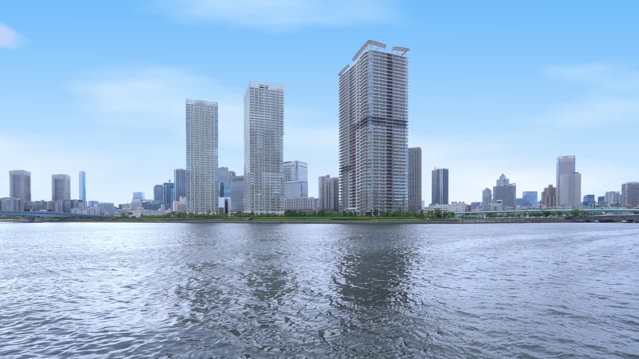 A wide, peaceful shot of the Tokyo skyline from the bay with tall skyscrapers and residential buildings