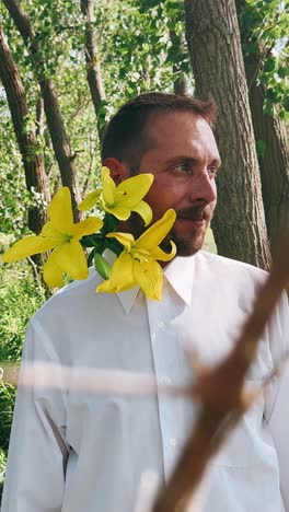 man with yellow lilies in nature