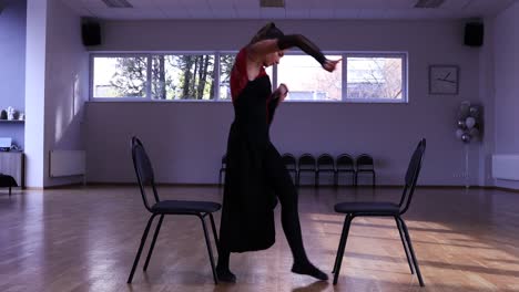 professional female dancer dances around two chairs