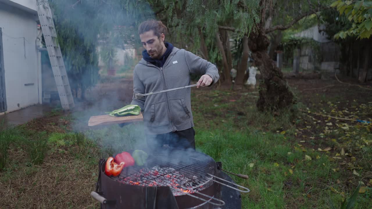 Man grilling vegetables in backyard