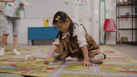 Niña-Jugando-Con-Diferentes-Piezas-En-La-Alfombra-En-El-Aula-En-Una-Escuela-Montessori