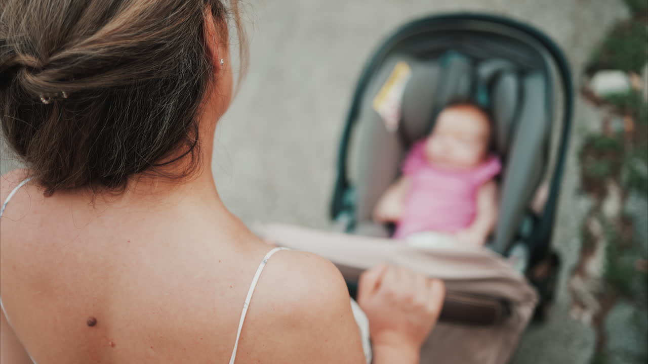 Woman in floral dress pushing a baby stroller outdoors