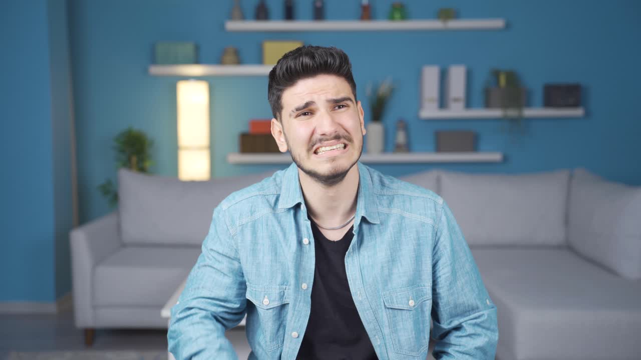 un joven frustrado y deprimido mirando a la cámara.