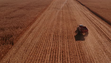 4K-AERIAL-FOOTAGE-OF-COMBINE-OPERATION-WITH-SUPPORTING-TRACTORS-REAPING-WEATH-IN-QUEBEC-CANADA