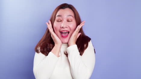 portrait of young asian lady with a positive expression, joyful surprise funky and looking at camera over violet background