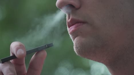 close up of male model smoking vaporizer outside slow motion