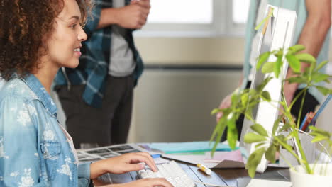 una mujer de negocios casual sonriente usando una computadora.