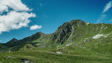 timelapse of fast moving clouds over a swiss hillside where hikers are walking