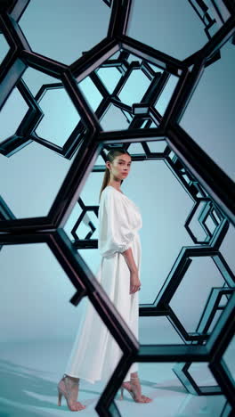 woman modeling white dress with geometric hexagonal structure