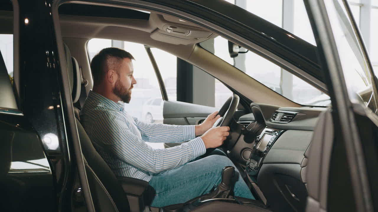 hombre conduciendo un suv negro en un concesionario de automóviles
