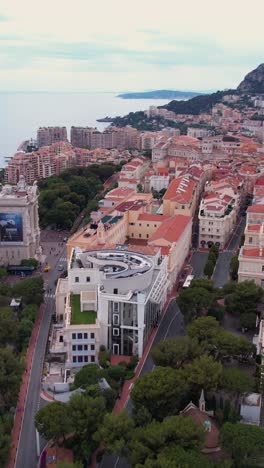monte carlo, monaco. vertical drone shot of old town on hill above mediterranean sea, prince's palace, cathedrals and museums