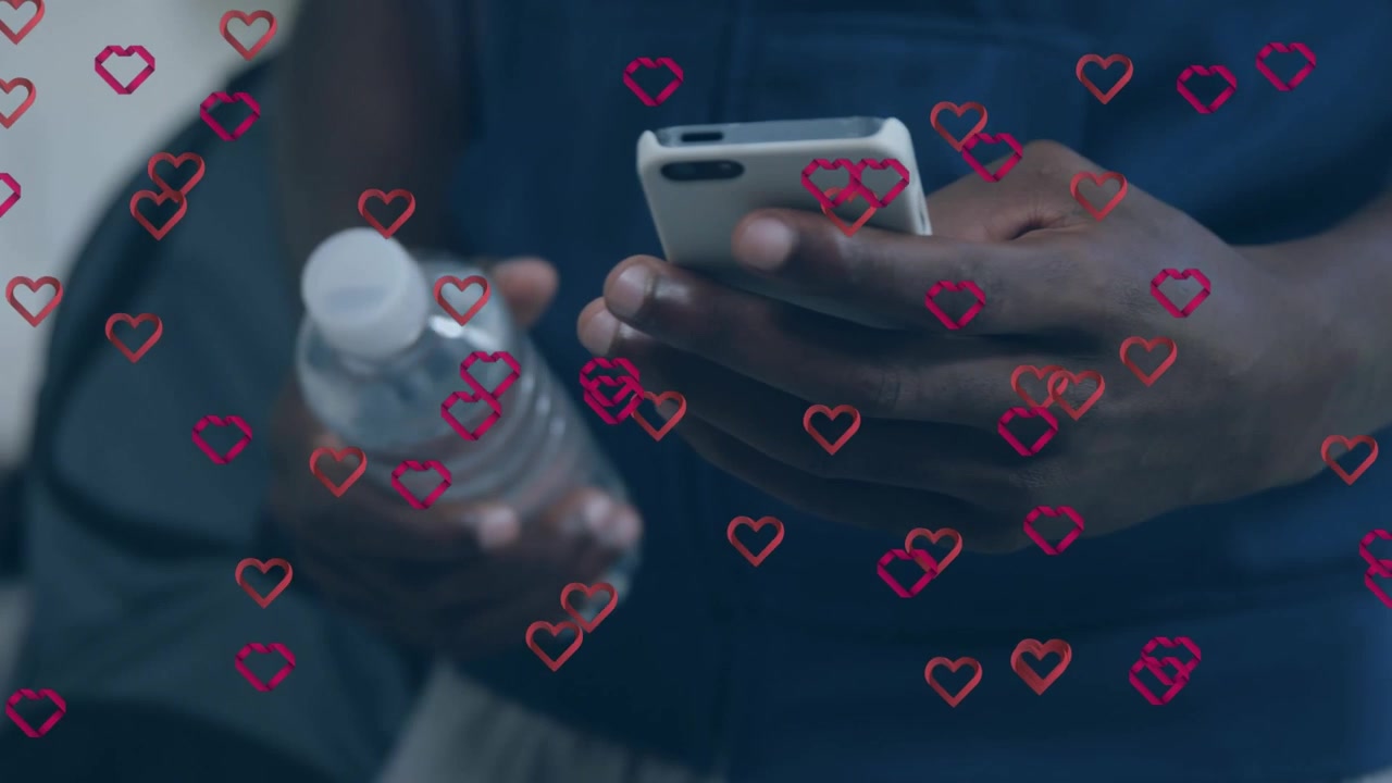 Animação de corações vermelhos sobre um homem afro-americano usando smartphone