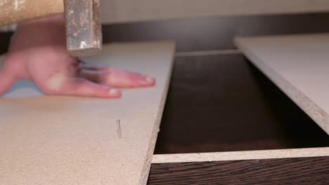 carpintero ensamblando muebles golpeando clavos martillo maestro profesional