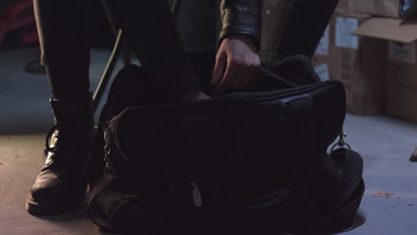 Criminal-opens-the-bag,-finds-black-leather-gloves-and-puts-them-on