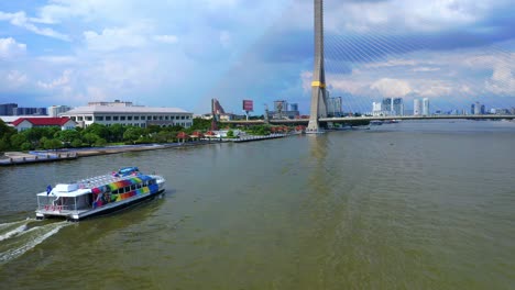 ferry boat sailing near rama viii bridge crossing the chao phraya river in bangkok, thailand