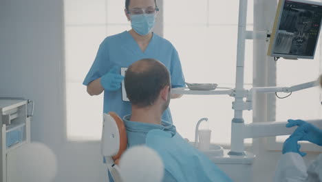 dentistry assistant holding digital tablet with teeth x ray scan