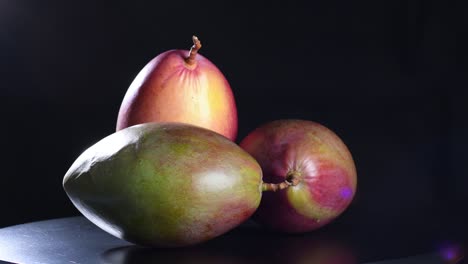mangoes gyrating in black background