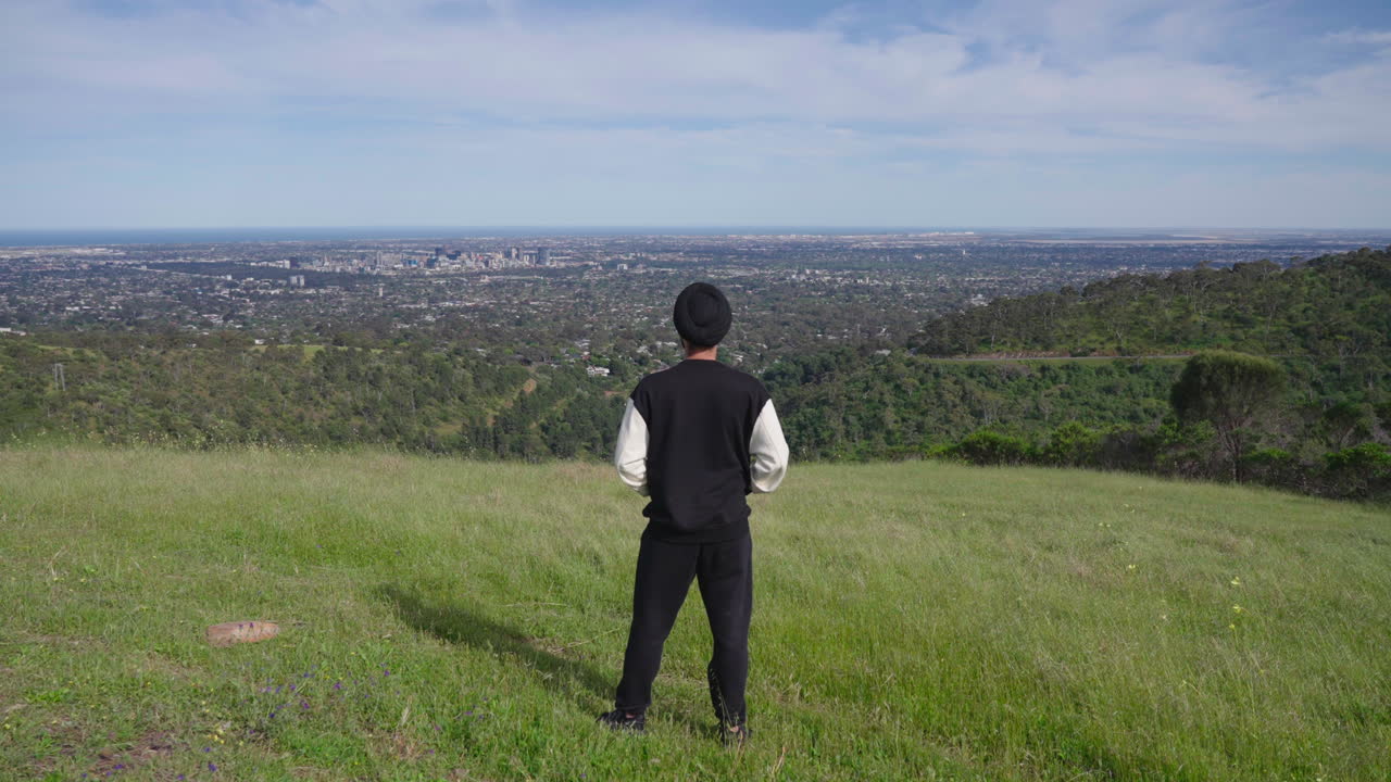 vista posterior de un hombre indio punjabi sikh mirando la hermosa vista de la montaña verde, el bosque y la ciudad