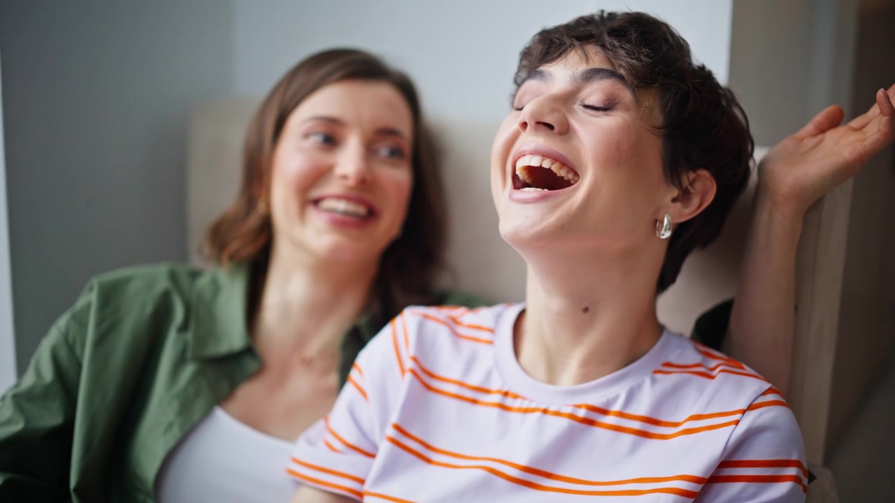 Primer plano de mujeres románticas en una cita en casa, riendo y disfrutando de una comunicación positiva.