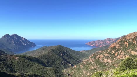 Panoramic-panning-view-of-Scandola-UNESCO-stunning-nature-reserve-in-summer-season,-Corsica-island-in-France