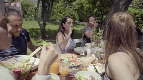 friends gathering around table in backyard