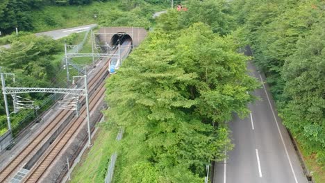 aerial shot of the hokuriku shinkansen emerging from a tunnel just before arriving at karuizawa station on its way to kanazawa station