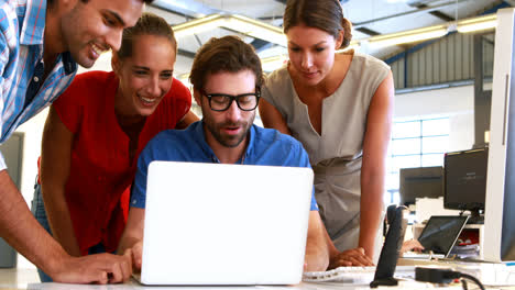 personas de negocios interactuando mientras usan una computadora portátil