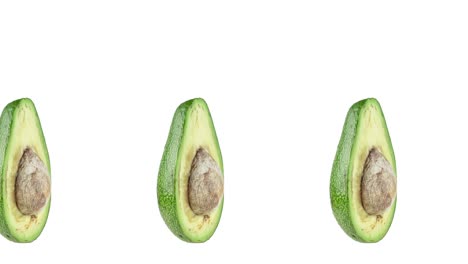 muchas mitades de aguacates girando de cerca sobre un fondo blanco. animación de bucle sin costuras con espacio de copia