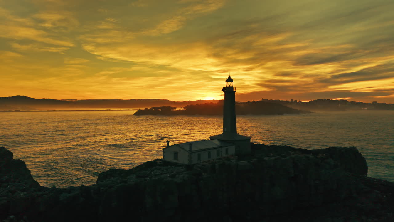 Faro su una scogliera al tramonto dorato