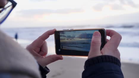 Una-Mujer-Hace-Un-Video-Con-Un-Teléfono-Inteligente-Durante-La-Puesta-De-Sol-En-Una-Increíble-Playa-De-Sylt