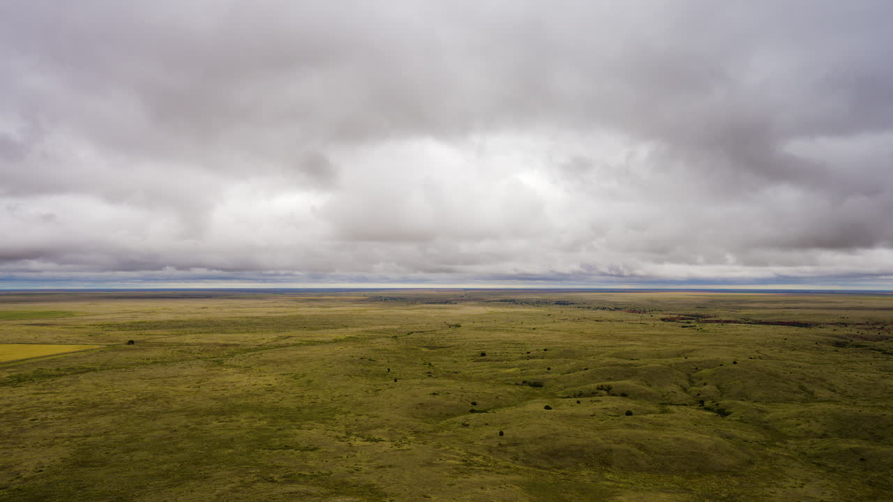Overskyet himmel over vidtstrakte græslandskaber i vidvinkel timelapse.