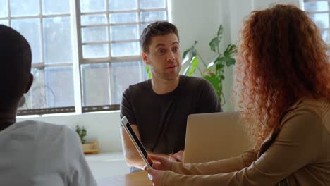 jong, cool, gemengd team van zaken die plannen maken en zitten in de cafetaria van een modern kantoor.