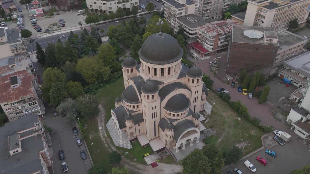 Aerial overhead circling shot showing Catedrala Adormirea Maicii Domnului surrounded by evening colors