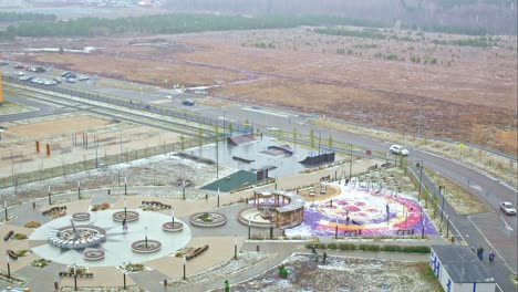 timelapse of weather with dolly zoom effect cars drive along the road, the first snow falls on the streets of the city and covers the ground and a park in residential area of the city northern cities