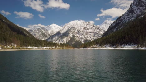 低角度空中景觀在平面上方奧地利湖向冷山雪覆蓋的山頂風景