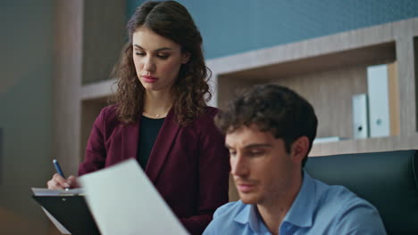 Boss giving papers secretary at office workplace close up. Director reading deal