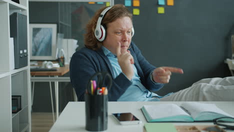 man listening to music and dancing in office