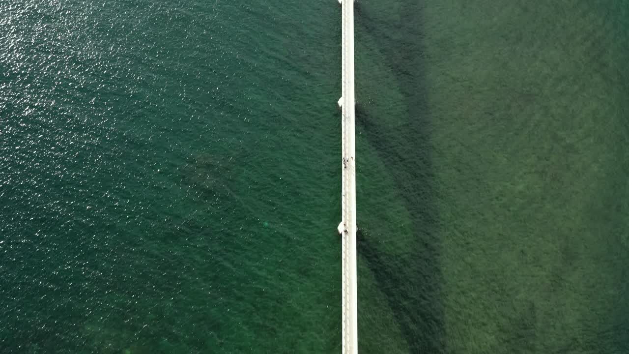 사마나만의 본토와 섬을 연결하는 에메랄드 바다 위의 긴 보행자 다리