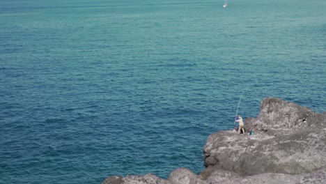 fisherman on a cliff by the sea