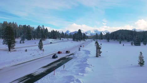 2020---Antena-De-Automóviles-Que-Conducen-Viajes-En-Una-Carretera-De-Montaña-Cubierta-De-Nieve-Helada-En-Las-Montañas-Del-Este-De-Sierra-Nevada,-Cerca-De-Mammoth-California