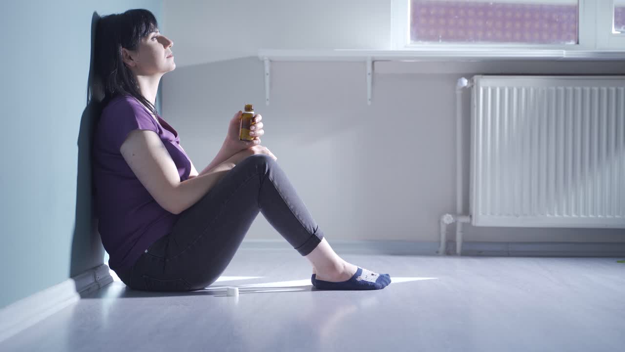 la mujer que mira las pastillas en su mano y va a suicidarse.