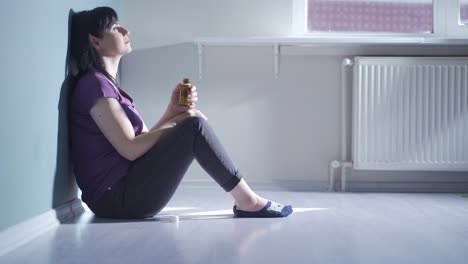 la mujer que mira las pastillas en su mano y va a suicidarse.