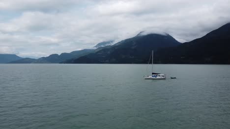 Luftaufnahmen-über-Wasser-Mit-Bergen-Und-Wolken-Im-Hintergrund