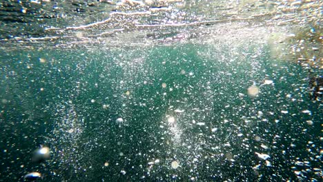 Cinematic-bubbles-rise-through-open-green-and-blue-open-ocean-water