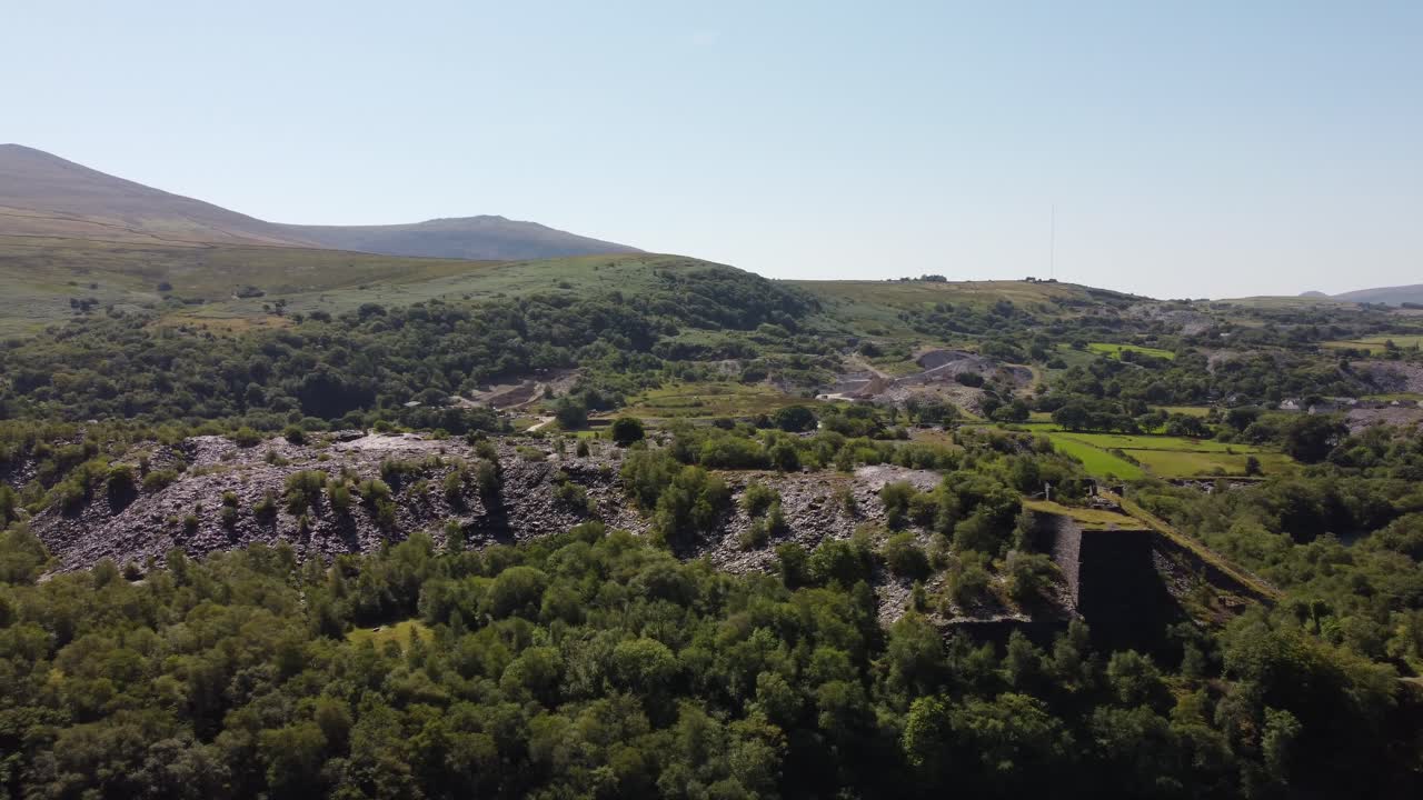dorothea cantera minera de pizarra cubierta de maleza en desuso en una densa y exuberante vista aérea de snowdonia mountain woodland vista panorámica izquierda