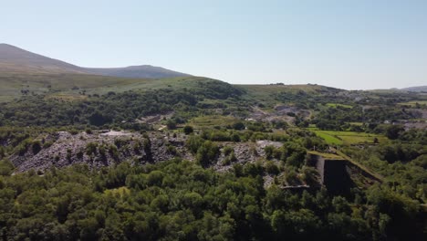 Dorothea-Cantera-Minera-De-Pizarra-Cubierta-De-Maleza-En-Desuso-En-Una-Densa-Y-Exuberante-Vista-Aérea-De-Snowdonia-Mountain-Woodland-Vista-Panorámica-Izquierda