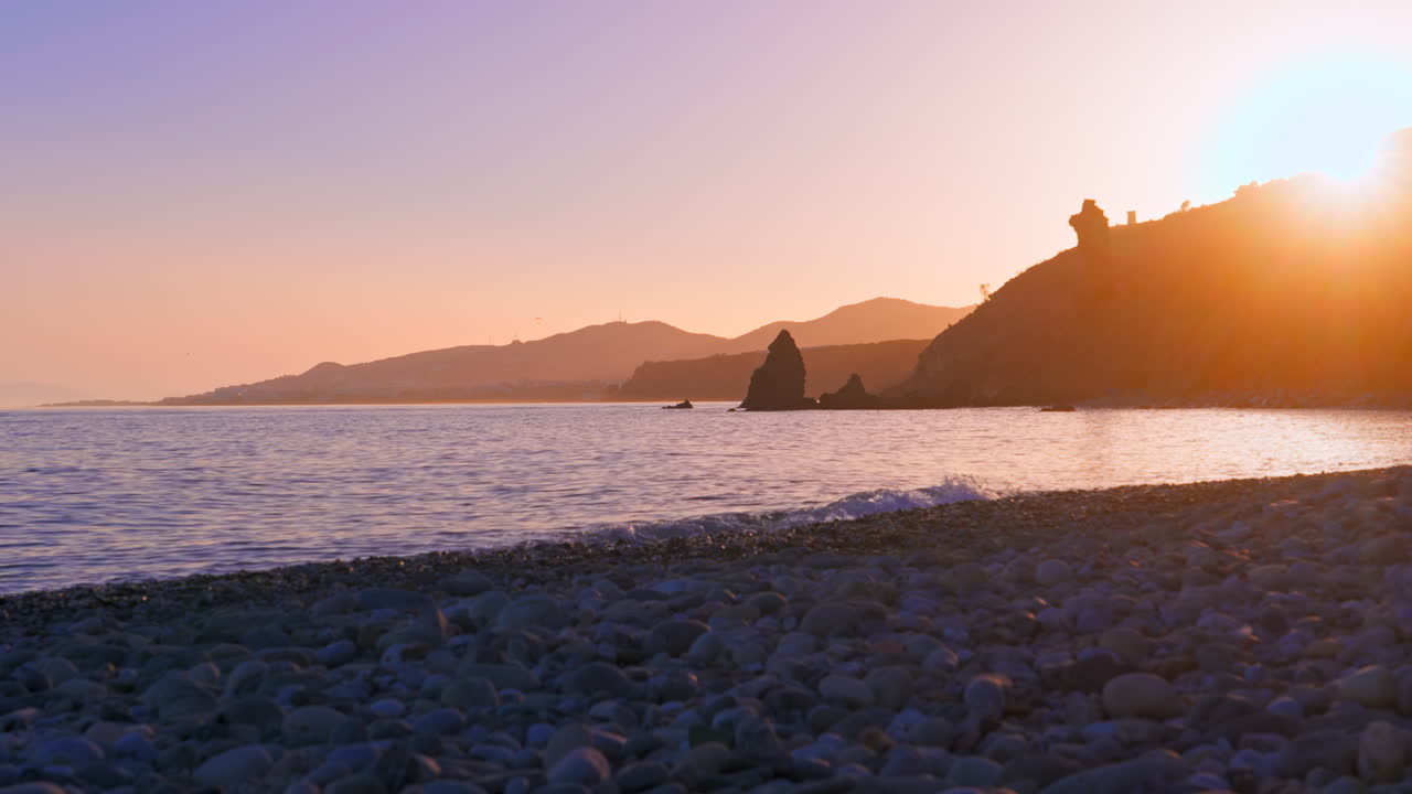 해가 지는 동안  ⁇ 은 하늘과 함께 스페인 지중해 바위 해변에 있는 평온한 바다 파도