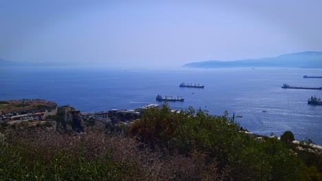 view from the rock of gibraltar of cargo and container ships passing through the strait