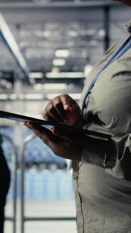 vertical video data center programmers check ai dashboard using tablet, doing systems review